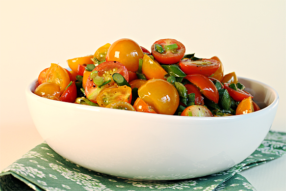 Flash-sautéed cherry tomatoes with garlic scapes and chives