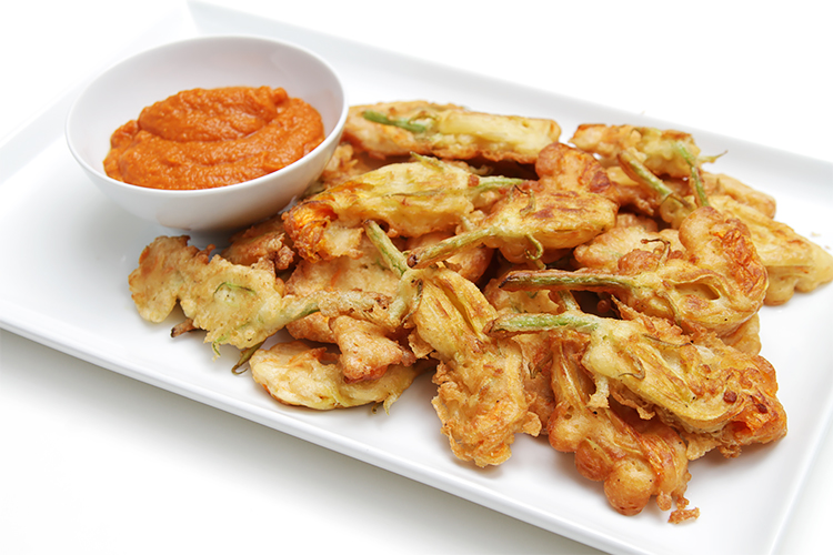 Beer-battered zucchini flower fritters with curried tomato coulis